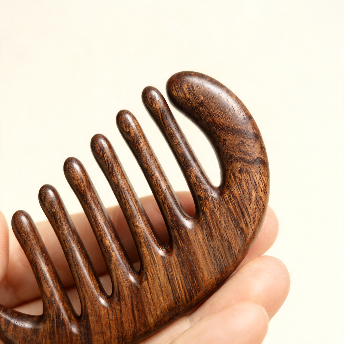 Close-up of the rounded polished teeth of the scalp massage comb